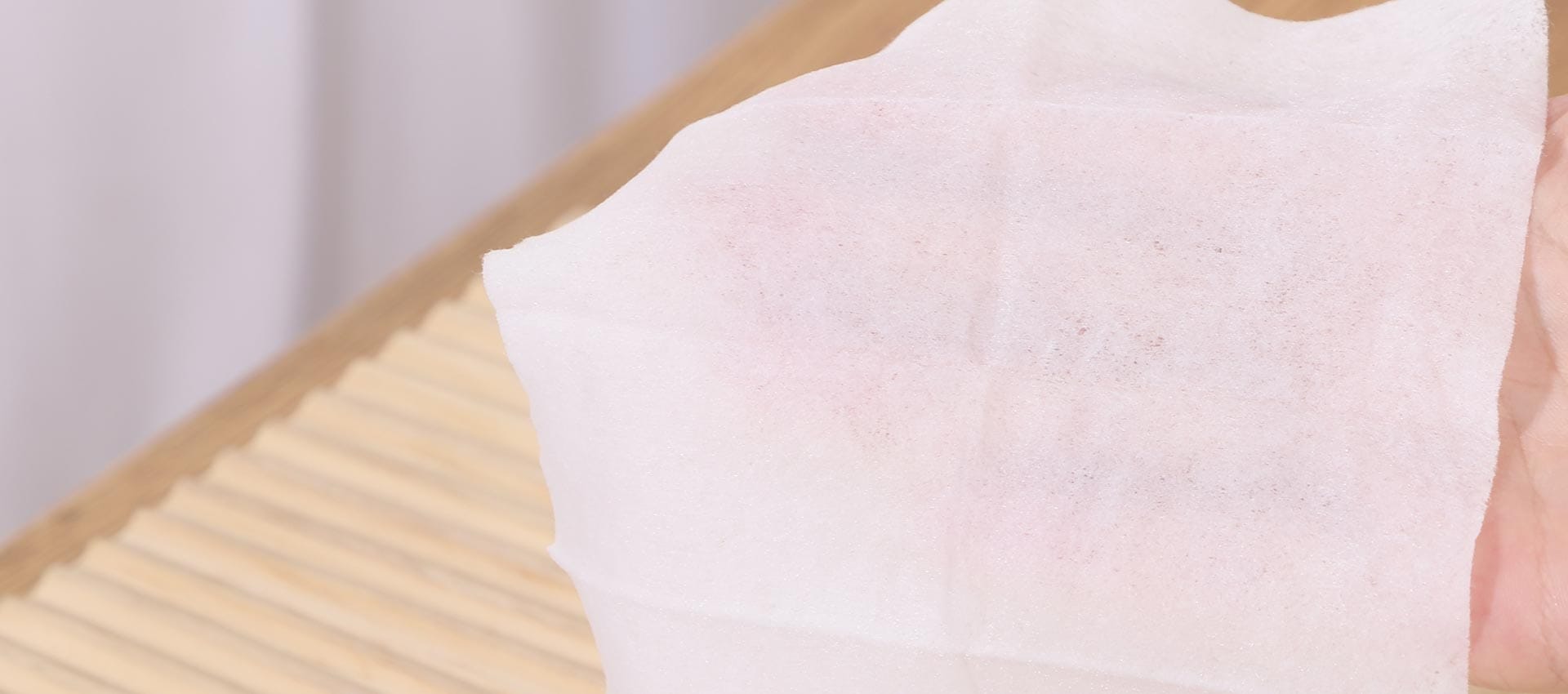 Close view of a textured white wipe held in a hand