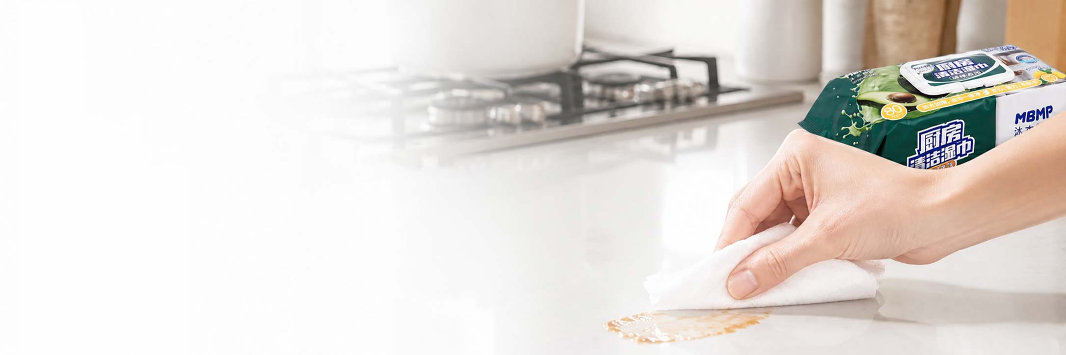 White wipe being retrieved from a green kitchen-wipe pack